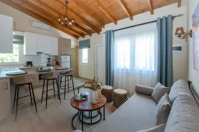 a living room and kitchen with a couch and a table at Villa Noelia in Rogdhiá