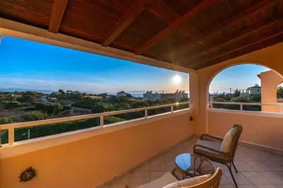 a balcony with chairs and a view of the desert at Koralia's Villas in Chorafakia