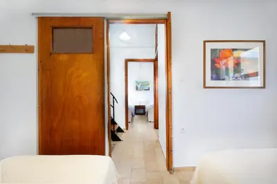 a hallway with a door and a room with a bed at Eleni Residences in Kalyves