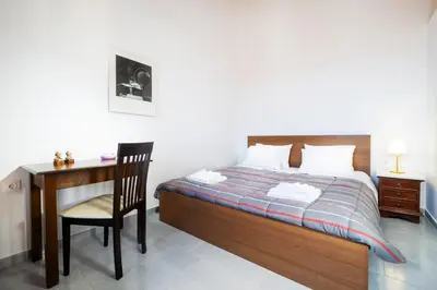a bedroom with a bed and a desk and a chair at Eleni Residences in Kalyves