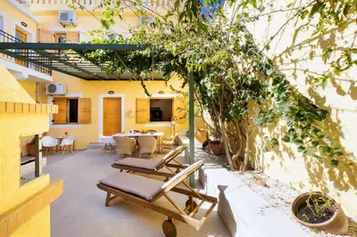 a patio with chairs and a table in a building at Eleni Residences in Kalyves