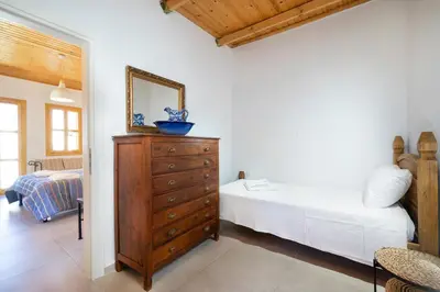 a bedroom with a bed and a dresser with a mirror at Eleni Residences in Kalyves