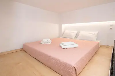 a bedroom with a pink bed with two towels on it at Rikanthos Stone Sea View Apartment ΙΙ in Kissamos