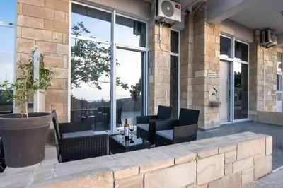 a patio with chairs and a table in front of a building at Rikanthos Stone Sea View Apartment ΙΙ in Kissamos
