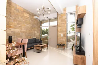 a living room with a stone wall at Rikanthos Stone Sea View Apartment ΙΙ in Kissamos