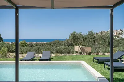 a swimming pool with lounge chairs and a view of the ocean at Seaview villa with pool in nature next to Platanias in Plataniás