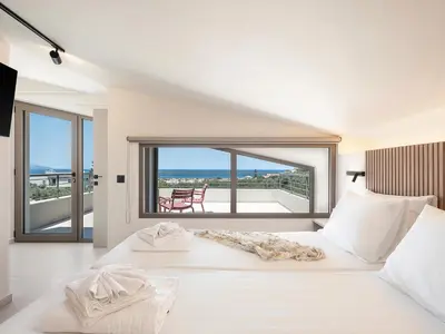 a bedroom with a large white bed with a large window at Seaview villa with pool in nature next to Platanias in Plataniás