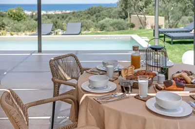 a table with plates of food on top of a table at Seaview villa with pool in nature next to Platanias in Plataniás