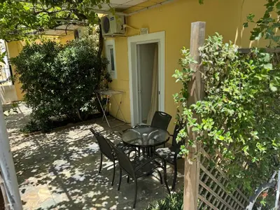 a patio with chairs and a table and a table and a fence at Michalis Studios & Aparntments in Palaiochóra
