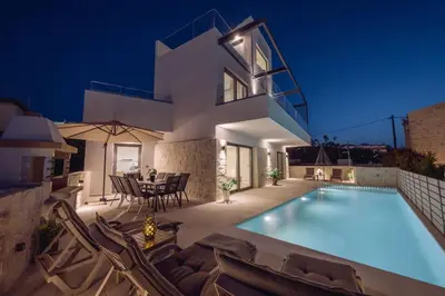 a villa with a swimming pool at night at Villa Icons in Agia Marina Nea Kydonias