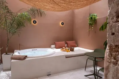 a bath room with a tub and a table at Qualia Slowlife Suites in Chania Town