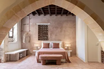 a bedroom with a bed and a chair in a room at Qualia Slowlife Suites in Chania Town