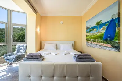 a bedroom with a white bed with towels on it at Naruto Villas in Kissamos