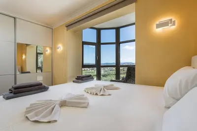 a bedroom with a large bed with a large window at Naruto Villas in Kissamos