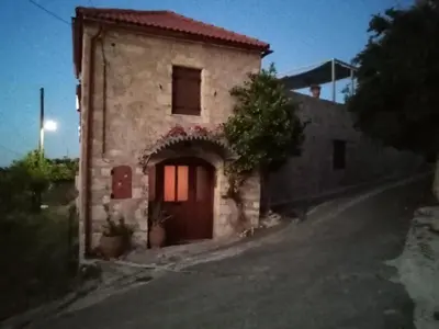 a building with a door on the side of a road at Charmante maison crétoise à Embrosneros in Embrósneros