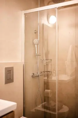 a shower with a glass door in a bathroom at Clio - Newly renovated Home with Parking in Chania Town