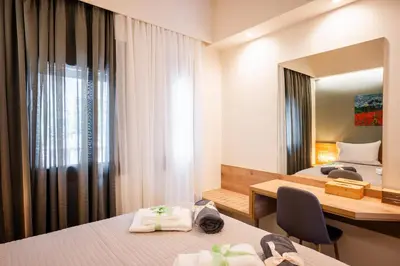 a hotel room with two beds and a mirror at Clio - Newly renovated Home with Parking in Chania Town