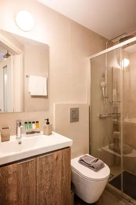 a bathroom with a toilet and a sink and a shower at Clio - Newly renovated Home with Parking in Chania Town