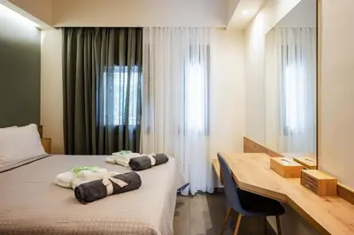 a hotel room with two beds and a desk at Clio - Newly renovated Home with Parking in Chania Town