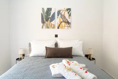 a bedroom with a bed with two white socks on it at Benessere in Chania Town