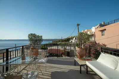 a balcony with a table and chairs and a view of the water at Delta-Rho in Kalami