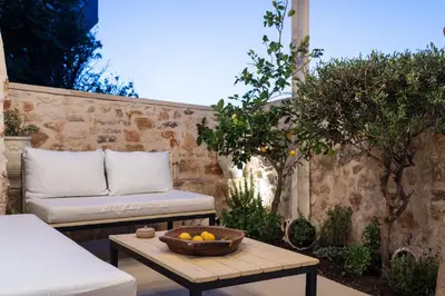 a patio with a couch and a bowl of fruit on a table at Delta-Rho in Kalami