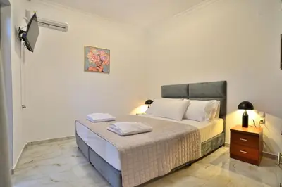 a bedroom with a large bed and a night stand at Anatoli Apartment in Kissamos