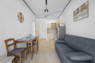 a living room with a couch and a table and a kitchen at Seafront Apartment in Chania 7 in Chania Town