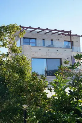 a building with a lot of windows and trees at Afea Villas in Plataniás