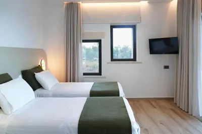 a hotel room with two beds and a flat screen tv at Afea Villas in Plataniás