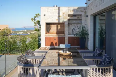 a patio with a table and chairs on a balcony at Afea Villas in Plataniás