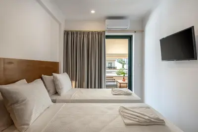 a bedroom with a bed with a television on a wall at Modern Dream Apartment in Plataniás