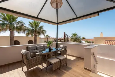 a patio with a table and chairs on a balcony at Modern Dream Apartment in Plataniás