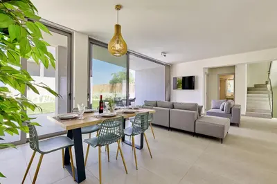 a dining room and living room with a table and chairs at Beach Sand Villas - Beachfront Roof Pool Seaviews in Pírgos Psilonérou