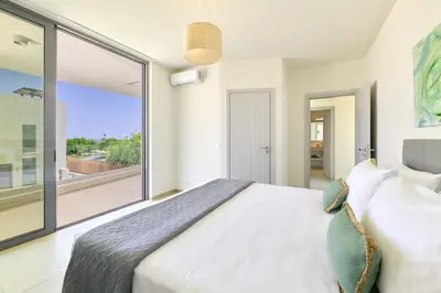 a bedroom with a bed and a large window at Beach Sand Villas - Beachfront Roof Pool Seaviews in Pírgos Psilonérou