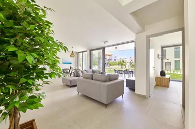 a living room with a couch and a table and chairs at Beach Sand Villas - Beachfront Roof Pool Seaviews in Pírgos Psilonérou