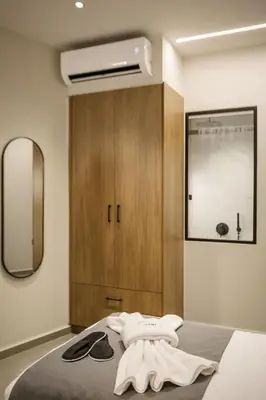a bedroom with a bed with a dresser and a mirror at Iria Sea View Room in Kolymvari