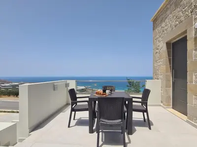 a table and chairs on a balcony with a view at Rosmari Studios in Falasarna