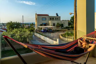 a woman sitting in a hammock looking out a window at Dream's House - Villa with Pool & Stunning Views in Daratso