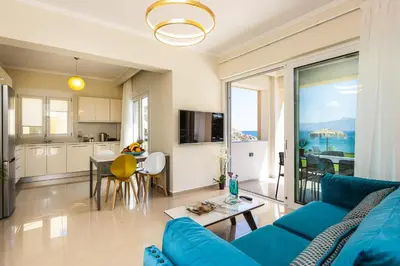 a living room with a blue couch and a kitchen at Harmony Villa in Chania Town
