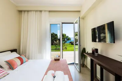 a bedroom with a bed and a sliding glass door at Harmony Villa in Chania Town