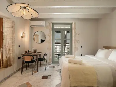 a bedroom with a bed and a table with chairs at Steki Luxury Room 1 in Chania Town