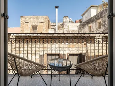 a table and chairs on a balcony with a view at Steki Luxury Room 1 in Chania Town