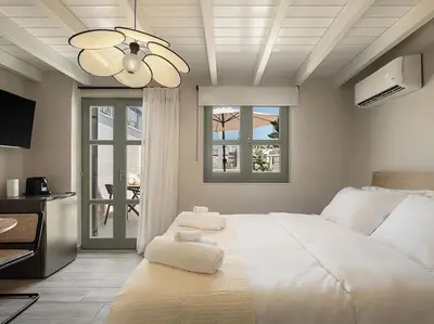 a bedroom with a large white bed with a ceiling fan at Steki Luxury Room 3 in Chania Town