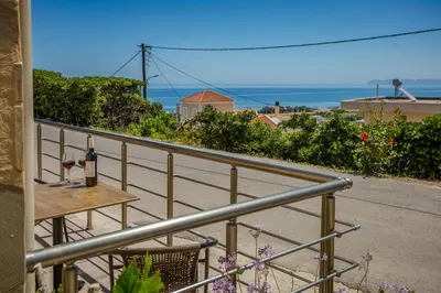 a balcony with a table and a view of the ocean at Petra's Charming Home, 500m to Beach in Chania Town