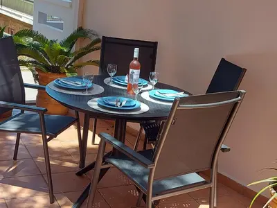 a dining room table with a bottle of wine and chairs at Eolia apartment in Chania with Sea&City View in Chania Town