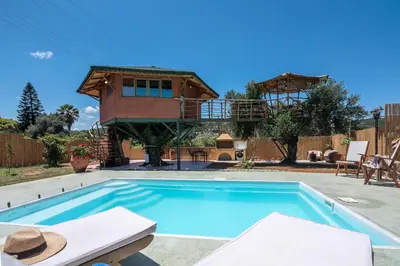 a house with a swimming pool and a tree house at Eco Olive Treehouse in Chania Town