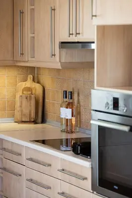 a kitchen with wooden cabinets and a stove top oven at Olive Garden Villa 5 min from Golden Beach in Galatás