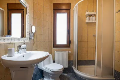 a bathroom with a sink and a toilet and a shower at Olive Garden Villa 5 min from Golden Beach in Galatás