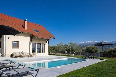 a house with a swimming pool next to a house at Olive Garden Villa 5 min from Golden Beach in Galatás